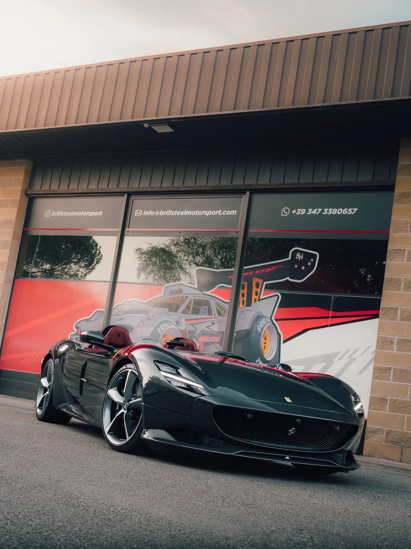 Black Ferrari Monza SP2 barchetta front three-quarter at Brill-Steel workshop