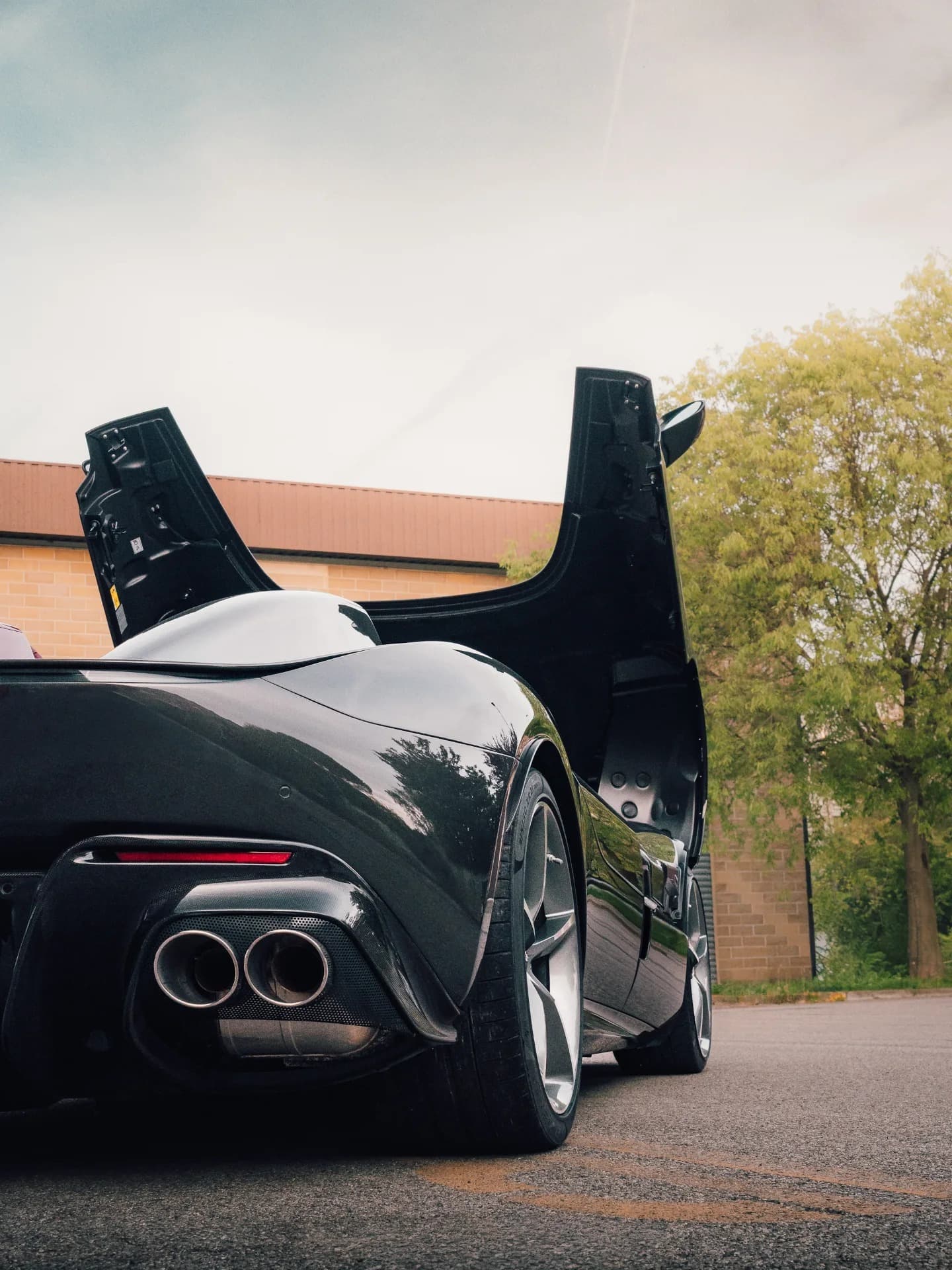 Ferrari Monza SP2 rear with quad exhaust framed by trees