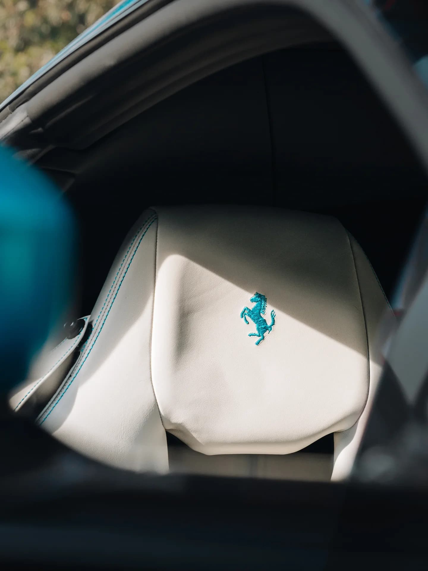 Ferrari interior with teal prancing horse embroidery on cream leather