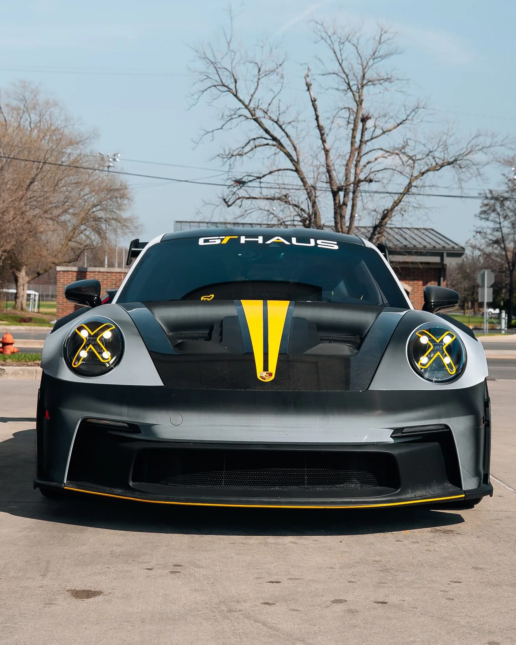 Front view of a Porsche 911 GT3 RS with a carbon hood and yellow accents